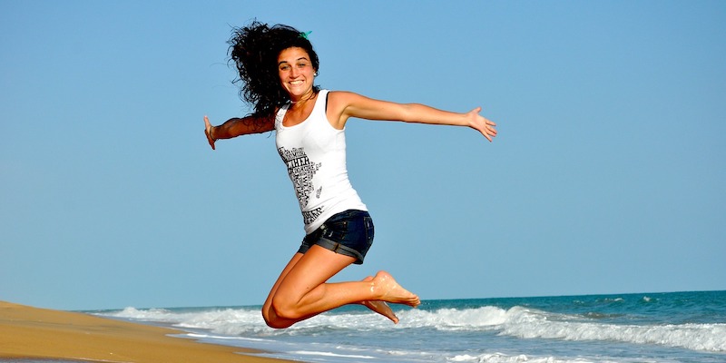 girl-on-beach-jumping-for-joy