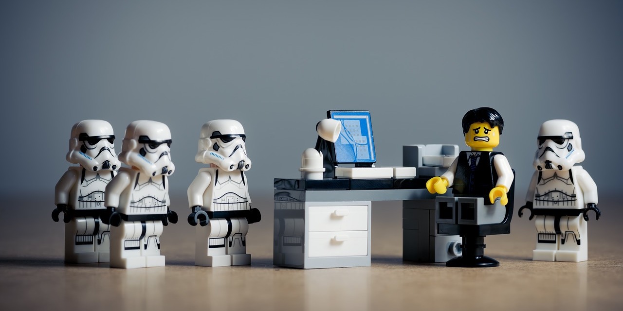 lego-man-at-desk-surrounded-by-stormtroopers